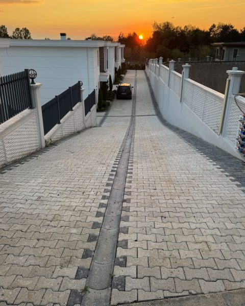 Gün batımında tamamlanmış parke taşı site yolu ve orta yağmur oluğu